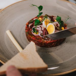 Edle Vorspeise mit Brot und Beef Tatar im Restaurant Woodfire im Hotel Grauer Bär Innsbruck.