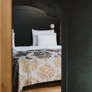 Modern eingerichtetes Schlafzimmer mit Holzdetails in den H5 Studios by Hotel Grauer Bär Innsbruck.
