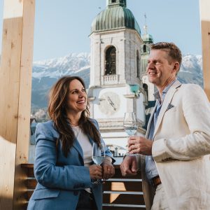 Paar genießt den Blick auf Innsbruck vom Balkon der H5 Studios by Hotel Grauer Bär Innsbruck.