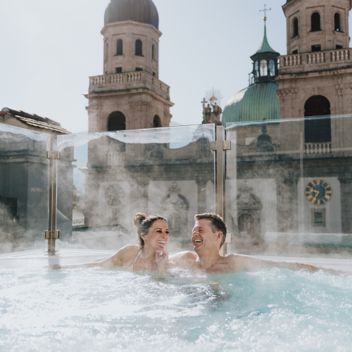 WellnessH5 Paar sitzt im Outdoor Whirlpool des Partnerhotels Grauer Bär während Aufenthalt in den H5 Studios